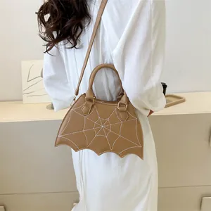 Detail view of brown bat-shaped PU leather bag with white spider web embroidery
