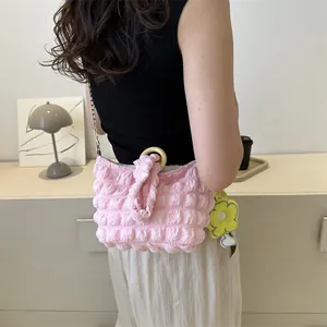 Pink bubble textured handbag with round wooden handle and yellow floral charm detail