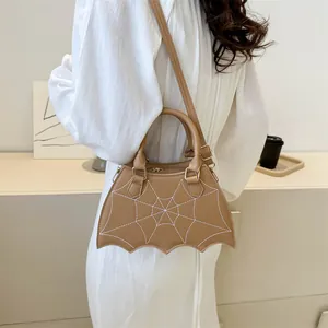 Detail of khaki spiderweb-shaped handbag with white stitching and leather texture