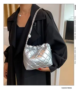 Silberne Stepp-Beuteltasche mit Metallic-Effekt und Kettenschultergurt am Model