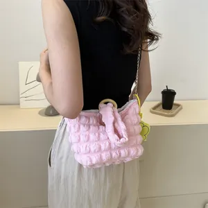 Detail of pink bubble texture shoulder bag with gold chain and circular wooden handle