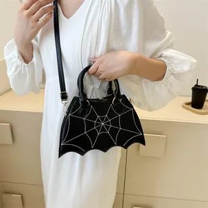 Detail of black spider web embroidery on a bat-shaped PU leather crossbody handbag