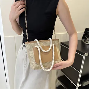 Détail du sac fourre-tout tissé avec poche en cuir marron et poignée en corde sur modèle