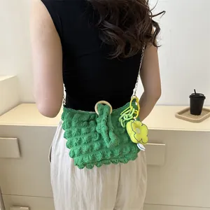Detail of green bubble textured shoulder bag with wooden handle and floral charm