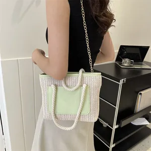 Détail du sac tissé avec poche en cuir vert et poignée en corde sur un mannequin
