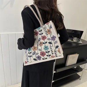 Vista lateral detallada del bolso tote de jacquard floral que muestra el tamaño y ajuste al hombro