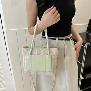 Détail du sac à main en paille tissée avec garniture en similicuir vert clair et chaîne