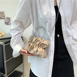 Vue détaillée du sac beige plissé avec poignée ronde sertie de strass et chaîne argent