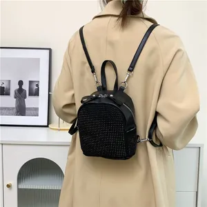 Detailansicht eines schwarzen Mini-Rucksacks mit Strass und Lederschleife
