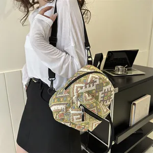 Sac à dos ethnique tissé avec motifs géométriques porté en sac de poitrine croisé