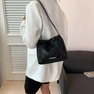 Detail der schwarzen Stepptasche mit Silberbeschlägen und Kettenriemen für Damen