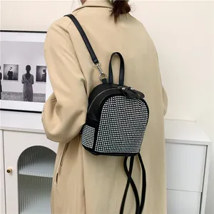 Detailansicht eines Mini-Rucksacks in Schwarz mit silbernen Strasssteinen und Metallreißverschluss