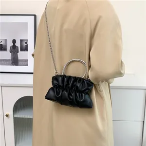 Détail du sac bandoulière plissé noir avec poignée en strass étincelants et chaîne