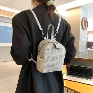Rückansicht eines silbernen Strass-Mini-Rucksacks am Modell in minimalistischer Umgebung
