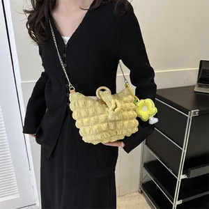 Detail of yellow bubble texture bag with wooden handle and sunflower charm accessory