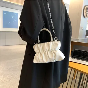 Détail du sac nuage blanc plissé avec poignée en strass et bandoulière chaîne argentée