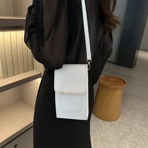 Minimalist white leather phone bag with gold metal clasp on model in black dress