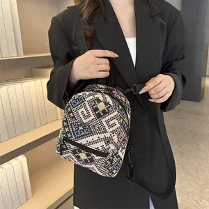 Détail d'un sac à dos tissé bohème montrant des motifs géométriques et des ferrures