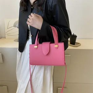Detail of pink litchi texture leather handbag with elegant gold hardware and secure clasp