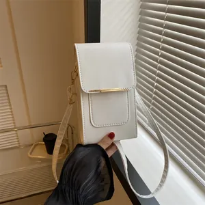 Detailed close-up of white leather vertical phone bag with gold metal buckle and strap