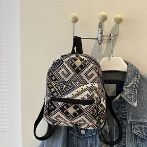 Détail du motif tissé géométrique ethnique sur un petit sac à dos près d'une veste en jean