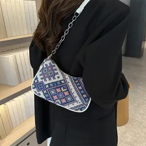 Detalle del tejido geométrico bohemio y los bordes de cuero blanco en el bolso de hombro