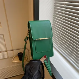 Detailed view of green faux leather crossbody bag with gold metal trim and magnetic flap