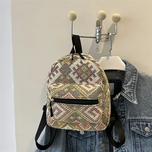 Gros plan d'un sac à dos ethnique tissé avec motifs géométriques colorés et sangles noires