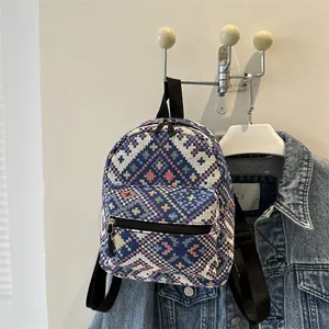 Détail du tissage aux motifs bohèmes sur un petit sac à dos bleu marine élégant