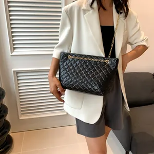 Detail of vintage quilted leather tote bag with gold chain strap shown on a model