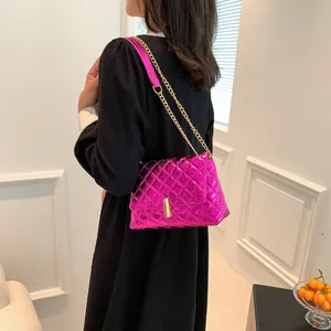 Detail of rose pink metallic quilted crossbody bag with gold chain strap on model