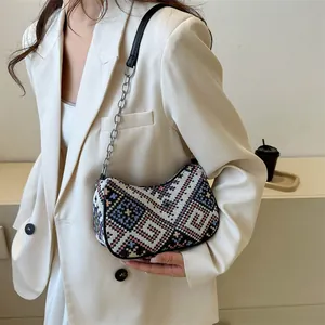 Detalle del bolso de media luna bohemio con texturas tejidas geométricas de colores