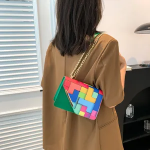 Detail view of colorful geometric block pattern shoulder bag with a gold chain strap