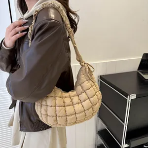 Détail du sac bulle matelassé beige avec texture plissée et bandoulière en demi-lune