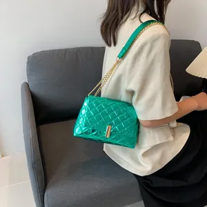 Chic quilted metallic green crossbody bag with gold chain strap shown on a model