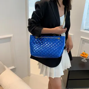Polished royal blue quilted tote bag featuring glossy patent leather and gold chain strap