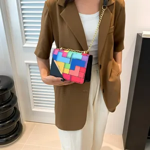 Detail of colorful geometric Tetris pattern crossbody bag with golden chain strap