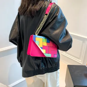 Detail view of macaron colored chain bag with geometric color blocks and gold chain strap