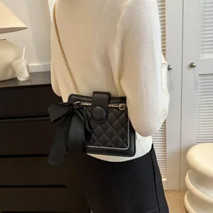 Quilted black crossbody bag for women with large silk bow and gold chain strap