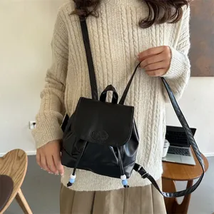 Dettaglio mini zaino in pelle PU nera con perline di chiusura e logo alla moda