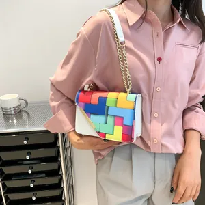 Macro shot of colorful geometric block pattern on a white chain crossbody handbag