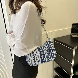 Detalle del bolso de hombro bohemio con patrón geométrico y correa de cuero azul