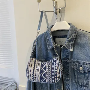 Detalle del bolso bohemio con estampado geométrico azul y cadena plateada fina