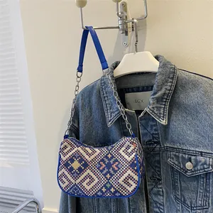 Vista detallada del patrón étnico tejido y la textura de la tela de este bolso de hombro