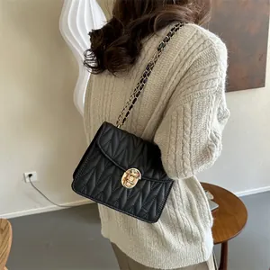Detailansicht der schwarzen Stepptasche mit goldenem Drehverschluss und Kettenriemen