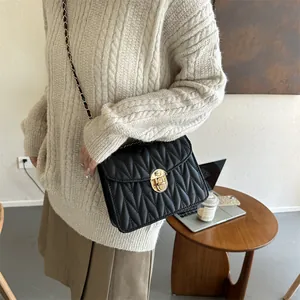 Detail der schwarzen Stepptasche aus Leder mit goldenem Verschluss und Kette