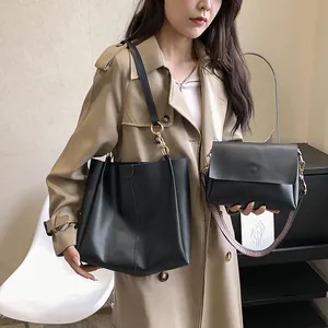 Conjunto de bolso tote y bandolera de cuero negro con correa ancha de tela estampada
