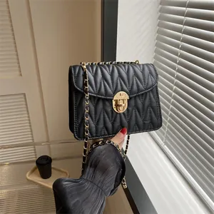 Nahaufnahme der schwarzen Stepptasche mit goldener Kette und Metallverschluss-Detail