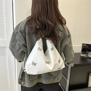 White glossy PU shoulder bag with silver 3D metal butterfly ornaments on denim jacket