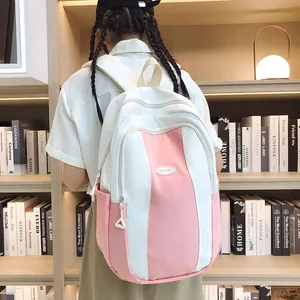 Detail of pink and white color-block backpack worn by a model in a library setting
